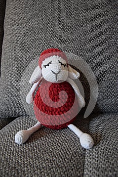 A handmade crochet red and white lamb