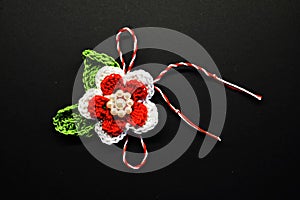 Handmade crocheted flower with red and white string, known as Martisor.