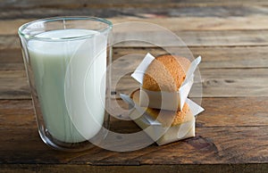 Handmade cupcake and glass of milk on a wooden background. Copy space. Handmade traditional Spanish photo
