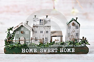 Handmade decor with a row of wooden houses and inscription Home sweet home