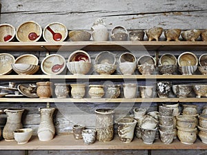 Handmade different clay dish on shelf, Lithuania