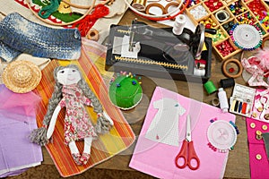 Handmade doll and clothing pattern, sewing accessories top view, seamstress workplace, many object for needlework, embroidery and