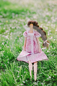 A handmade doll on the grass background