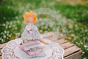 A handmade doll on the grass background