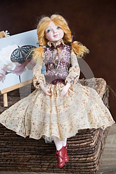 Handmade doll in a rustic dress sits on a table
