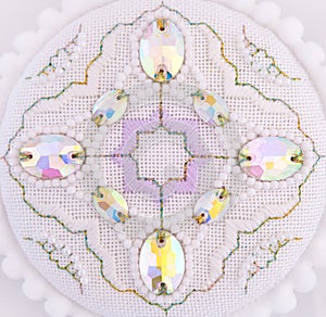 A handmade embroidery with white, purple and gold - green threads, white beads and crystals on it. 4