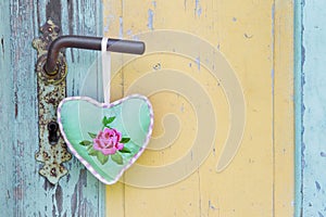 Handmade fabric heart hanging on an old door handle for a summer