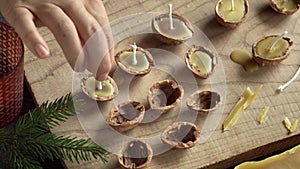 Handmade fabrication of Christmas candles from walnut shells and bees wax
