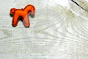 Handmade felt horse decorated with beads on wooden background.