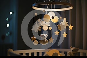 Handmade felt toys above the newborn crib with light garland in the night. Baby crib mobile, first baby eco-friendly toys, cozy