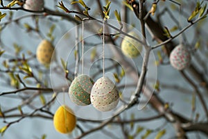 Handmade felted easter eggs hanging on decorative branches