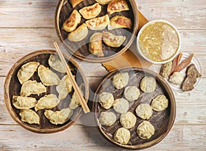 Handmade fried dumplings with steamed dumpling or momo served in wooden dish with Mixed soup chopsticks isolated on table top view