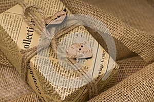 Handmade gift box with a natural rope and two wooden hearts on sackcloth, Valentines Day background