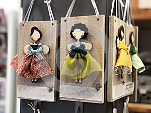 Handmade girls-angels in multicolored dresses on wooden boards. Toys. Market display