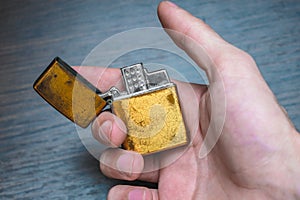 Handmade golden lighter on a dark background in yellow and blue tones