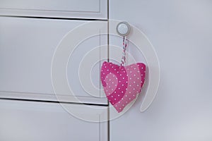 Handmade heart of scrim hanging on the wooden dresser