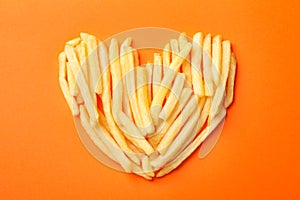 Handmade heart with tasty french fries on background, top view