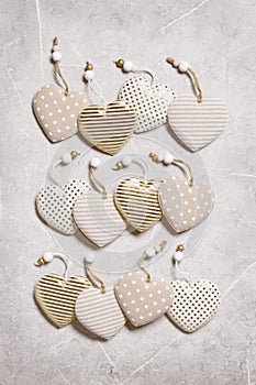 Handmade hearts from cloth with golden color striped or dots on gray marble background. Valentines Day pattern and love