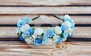 Handmade hoop blue flowers. Blue hair band on wooden background