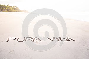 Handmade inscription on the sand of a beach with the phrase pure life