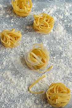 Handmade italian pasta - tagliatelle on floury background