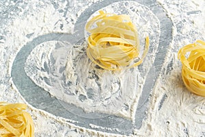 Handmade italian pasta - tagliatelle on floury background