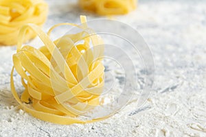 Handmade italian pasta - tagliatelle on floury background