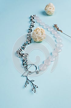 Handmade jewellery. Silver chain necklace and white quartz stones, on a blue background