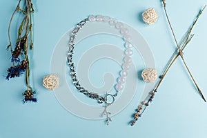 Handmade jewellery. Silver chain necklace and white quartz stones, on a blue background