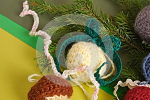 handmade. knitted balls for the Christmas tree, various crocheted Christmas toys, fir branches.