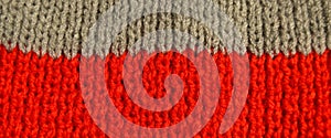 Handmade knitted fabric red white and grey wool background texture