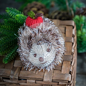 handmade knitted hedgehog with a red apple on abasket