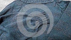 Handmade knitted products. Knitted fabric made of dark threads. Woman pullover