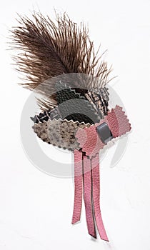 Handmade leather and feather brooch on white