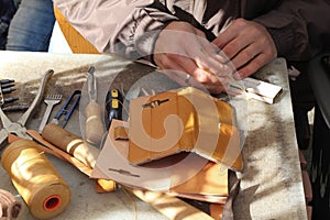 Handmade leather goods, craftsman at work in a workshop