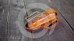 Handmade Leather Pancake Style Swiss Army Knife Sheath on wooden background. Stitching by hand.