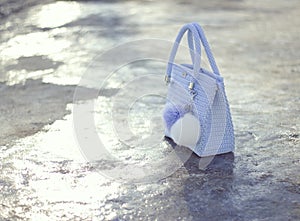 Handmade light blue textile knitted bag with pompons