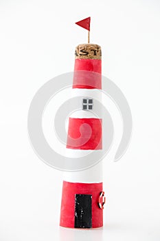 Handmade lighthouse from colored paper. Handicraft and hobby concept. Object on a white background