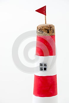 Handmade lighthouse from colored paper. Handicraft and hobby concept. Object on a white background