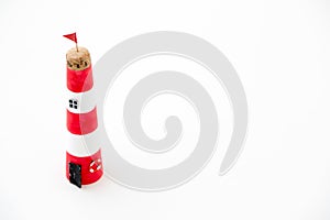 Handmade lighthouse from colored paper. Handicraft and hobby concept. Object on a white background