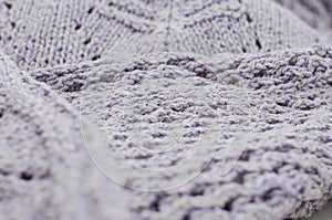 Handmade lilac knitting wool texture background. Close-up, selective focus