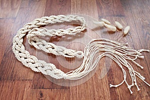 Handmade macrame dress belt closeup. Natural cotton threads. Stylish decoration for women `s dress.  Macrame pattern