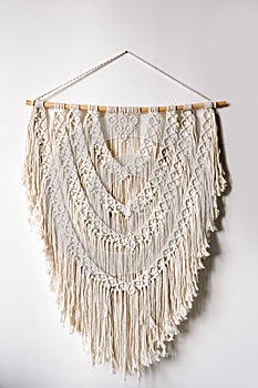 Handmade macrame hanging on white wall in bright room