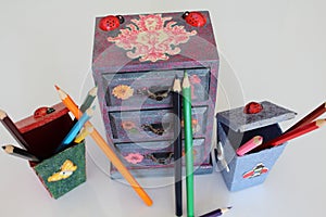 A handmade mini chest of three drawers decoupaged with floral vintage paper, handmade objects decorated using different techniques