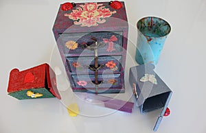 A handmade mini chest of three drawers decoupaged with floral vintage paper, handmade objects decorated using different techniques