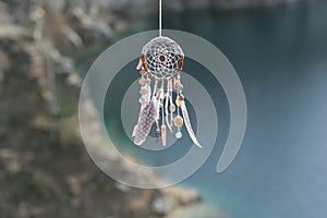 Handmade native american dream catcher on background of rocks an