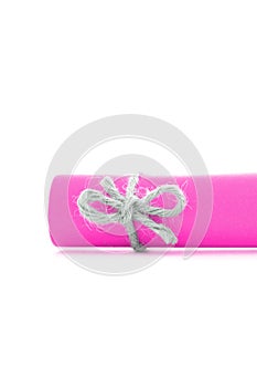 Handmade natural cord bow tied on pink paper scroll isolated