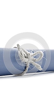 Handmade natural cord knot tied on blue paper scroll isolated
