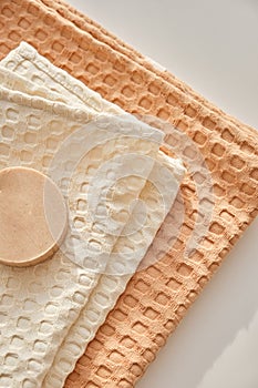 Handmade natural olive soap lies on a natural muslin towel. Composition in beige.