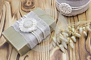 Handmade, natural organic olive oil soap and cosmetic salt on wooden background. Spa bath accessories, feminine care products. Hyg